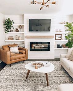 a living room with two couches and a television on top of a fireplace mantel