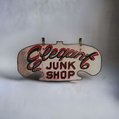 an old neon sign that is hanging on the wall in front of a white background