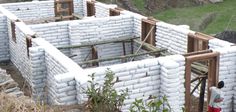 a man standing in front of a building made out of cinder blocks