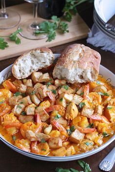 a bowl filled with shrimp and bread on top of a table