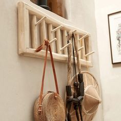 two purses are hanging on the wall next to a coat rack and hat rack