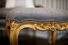 an ornate gold bench with blue upholstered cushion