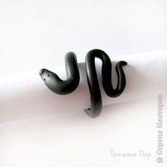 a black snake ring sitting on top of a roll of paper