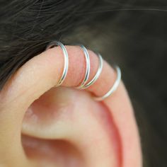 a close up of a person's ear with three thin rings on top of it