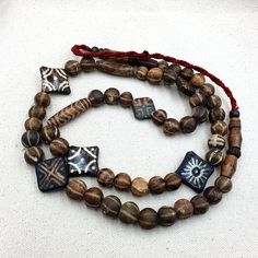 This exquisite necklace showcases a collection of South East Asian Old PUMTEK BEADS handcrafted from AGATIZED PALMWOOD. The beads come in a stunning MIXED color and feature unique patterns that add to their antique charm. The necklace is a true collector's item and is categorized under 1400-1800, Beads, and Collectibles. The intricate details and craftsmanship in each handmade bead are evidence of the rich cultural heritage of Burma. Add this one-of-a-kind strand to your collection today. Artisan Wooden Beads For Meditation, Artisan Wooden Meditation Beads, Traditional Wooden Beads Necklace For Meditation, Traditional Wooden Bead Necklaces For Meditation, Wooden Beads Amulet Necklace For Meditation, Handmade Amulet Mala For Rituals, Handmade Mala Amulet For Rituals, Meditation Amulet Necklace With Wooden Beads, Amulet Style Wooden Beaded Necklace For Gifts