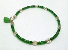 These are metal and glass bead wrap bracelets. They are comprised of glass seed beads, fire polish beads, and charms. The beads are strung on silver plated memory wire. 2" coiled - wraps to fit any wrist. Based on a design by Bridgette Coyer (Potomac Beads). Nickel-free Green Beaded Bracelets As A Gift, Nickel-free Green Beaded Bracelets For Gift, Nickel-free Green Beaded Bracelet For Gift, Green Nickel-free Beaded Bracelets As A Gift, Spiritual Green Beaded Czech Glass Bracelets, Spiritual Green Czech Glass Beaded Bracelets, Handmade Green Dangle Beaded Bracelets, Green Wire-wrapped Bracelets With Round Beads, Green Nickel Free Bracelets With Round Beads