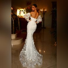 a woman in a white wedding dress standing on the floor with her back to the camera