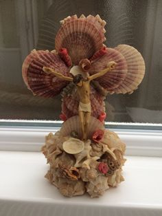 a figurine of a woman with seashells on her head and arms