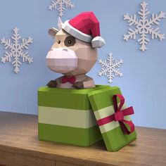 an origami animal in a santa hat sitting on top of a present box