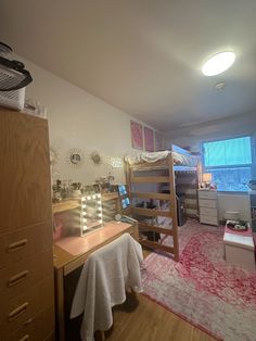 a bedroom with bunk beds, desk and dresser