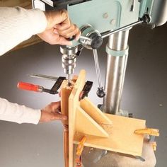 a person using a driller on a piece of wood with tools in front of it