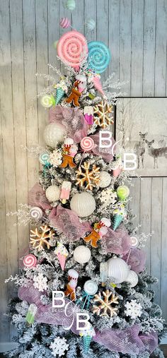 a white christmas tree decorated with candy and lollipops in pastel colors