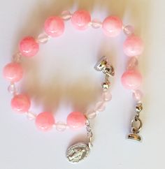 Handcrafted rosary bracelet, one decade. Made with 8 and 4mm natural pink Morganite gemstone beads. Small Miraculous Medal is from Italy. Hand knotted on cord. Magnetic closure. Approx. 7.5" Adjustable Pink Rosary Bracelet With 8mm Beads, Adjustable Pink Single Strand Beaded Bracelets, Adjustable Pink Single Strand Beaded Bracelet, Adjustable Single Strand Pink Beaded Bracelet, Spiritual Single Strand Bracelet, Handmade Pink Rosary Bracelet With Round Beads, Pink Adjustable Rosary Bracelet For Healing, Adjustable Pink Rosary Bracelet For Healing, Pink Spiritual Beaded Bracelet With 8mm Beads