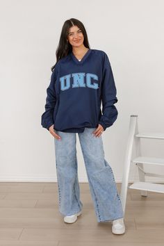 Stay comfortable and show your school spirit with our North Carolina Tar Heels Classic V-Neck Wind Shirt featuring a bold college logo. Designed for style and functionality, this lightweight layer offers wind protection with a timeless v-neck design, perfect for game days or casual outings. Navy Varsity Top For College, Collegiate Blue Tops For Campus, Blue Collegiate Tops For Campus, Collegiate Navy Top For Game Day, Navy Collegiate Top For College, Navy Collegiate Style Top, Blue Varsity Tops For Campus, Blue Varsity Top For Campus Wear, Blue Sporty Tops For Campus