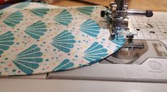 a sewing machine with a blue and white flowered fabric on it's side