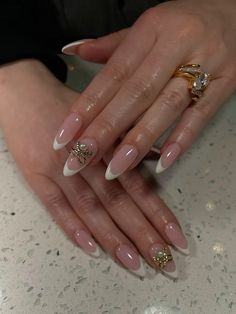 Almond nails with gold bow charm White French Tip Nails With Gold Charms, Gold And White Almond Nails, Gold Nail Charms, Gold Charm Nails, Almond Nails With Gold, White French Tip Nails, White Almond Nails, Nails With Gold, White French Tip