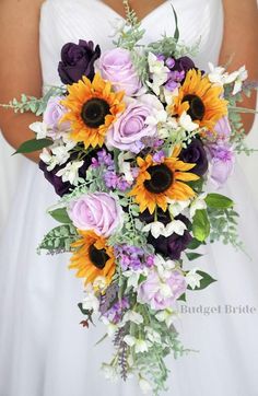 a bridal bouquet with sunflowers, roses and other flowers is held by a bride