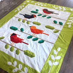 a quilted table runner with birds on it