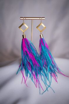 Bold festival statement earrings with brass hardware. All of my earrings are made for sensitive ears using gold filled wire hooks. I make my jewelry by hand using whimsical findings and/or polymer clay, and love playing with textures and colors. Details: Hypoallergenic gold-filled wire hooks Brass hardware with striking colorful feathers 5.5 inch dop Care: To keep your earrings looking their best, simply wipe them clean with a soft cloth. Handmade Artsy Earrings For Party, Whimsical Gold Earrings For Festival, Handmade Whimsical Brass Earrings, Blues Festival, Statement Drop Earrings, Colorful Feathers, Sensitive Ears, Brass Hardware, Statement Earrings