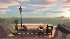 a wooden bench sitting on top of a sandy beach next to the ocean with a lit candle