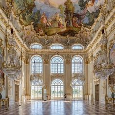 an ornately decorated room with chandeliers and paintings on the walls