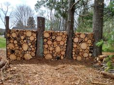 several pieces of wood stacked on top of each other in front of some trees and grass