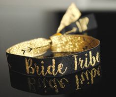 a black and gold bracelet with the words bride tribe printed on it's side