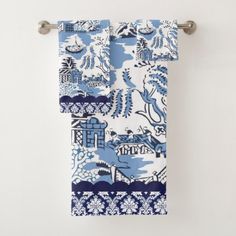 two blue and white towels hanging on a towel rack in front of a white wall