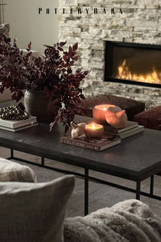 a living room filled with furniture and a fire place next to a stone brick wall