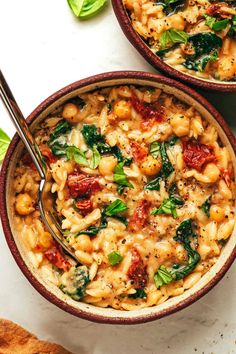 two bowls filled with pasta and spinach