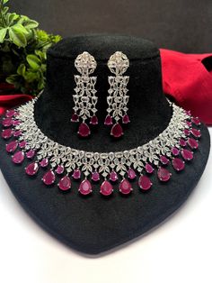 Gorgeous fine quality lab Ruby dark pink zircon and  diamonds studded necklace with white gold rhodium plating and matching Earrings Item contains: Necklace and earrings AAA quality cubic zirconia used. Highest quality and craftsmanship Necklace Fitting is adjustable Earrings Closure: Pushback Necklace Closure: chain with adjustable length Hook Details-  -Handmade item -Delivery from a small business in India -Materials: white rhodium, stones, cz, zircon, American diamond -Jewellery type: Earrin Fine Jewelry Sets With Cubic Zirconia For Celebration, Fine Jewelry Sets For Celebration With Cubic Zirconia, Hand Set Cubic Zirconia Dangle Necklaces, Fine Jewelry Bridal Necklace With American Diamond, Handcrafted Cubic Zirconia Dangle Necklaces, Cubic Zirconia Bridal Necklace For Party, Fine Jewelry Bridal Necklace For Party, Round Cubic Zirconia Bridal Necklace For Party, Party Jewelry With Round Cut Diamonds