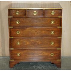 an antique chest of drawers with brass handles