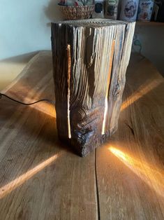 a wooden table with a light shining through the cut in half piece of wood on it