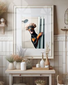 a framed photograph of a dog hanging on the wall above a table with vases