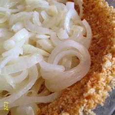 onions are being cooked in a bowl on the stove top with seasoning flakes