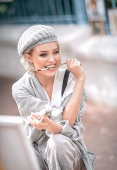 a woman sitting on the ground with a toothbrush in her mouth