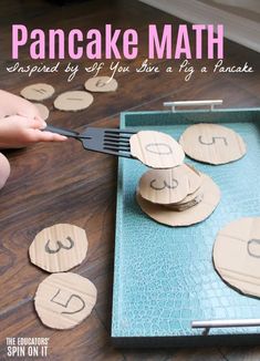 a pancake math game is being played on the floor with wooden discs and forks