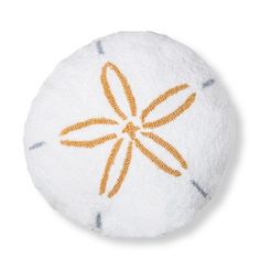 a white and orange round object with an orange flower on it