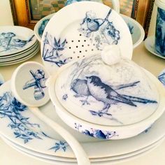 a table topped with plates and bowls covered in blue transfer transferal art design on them