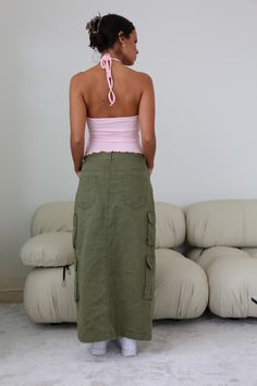 Step up your wardrobe game with the Olivia Cargo Maxi Skirt. Featuring Fall's staple color olive, this cargo maxi is designed to bring utility chic to life. Whether you keep it casual or dress it up, this is the piece you need to get you through the season in style! Make it your go-to and become everyone's style envy! Rigid with Minimal Stretch Center Front Slit Double Cargo Pockets 5 Pocket Maxi Silhouette 100% Cotton Model is 5'6 and wearing a size SMALL Green Cargo Maxi Skirt, Going Out Looks, Green Cargo, Corsets And Bustiers, Top Streetwear, Cargo Skirt, Denim Details, Dress Romper, Step Up