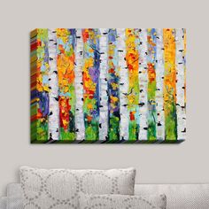 an abstract painting on the wall of a living room with white couches and pillows