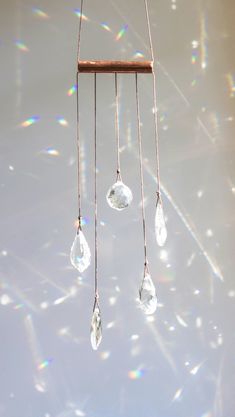 a wind chime hanging from the ceiling with crystal drops on it's strings