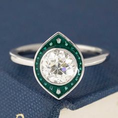 Inspired by the target halos of the Art Deco era, but our fresh take on the style using enamel! We set this chunky and bright antique Old Euro cut diamond in platinum, sitting in a navette-shaped halo of delicious green enamel with superfine milgrain detail throughout. Within that enamel halo are little mounds of platinum to help mimic faceting, giving the ring a really unique and special look. Spready on the finger and a bright, prismatic face up to boot! Platinum Size 5.75 & resizable Diamond White Gold Enamel Diamond Ring, Art Deco Enamel Anniversary Ring, Anniversary Art Deco Enamel Ring, Round Enamel Diamond Ring With Gemstone, Anniversary Enamel Ring With Bezel Setting, Silver Diamond Enamel Ring, Oval Enamel Ring With Bezel Setting For Anniversary, Target Ring, Modern Mens Rings