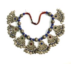 A stunning handmade necklace from Baluchistan kuchi tribe. The necklace is embellished with nine alloy beads and blue glass beads. Eight beautifully designed pendants are precisely positioned between each pair of alloy beads, with thirteen dangles suspended from each pendant. Every aspect of the necklace has been carefully crafted to represent the tribe's rich cultural heritage. The necklace is in good condition, with minor signs of wear consistent with its age . Cultural Heritage, Handmade Necklace, Jewelry For Women, Blue Glass, Handmade Necklaces, Favorite Jewelry, Jewelry Necklace Pendant, Glass Beads, Thailand