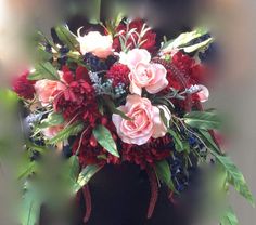 a vase filled with lots of red and pink flowers