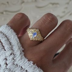 Step into a realm of ethereal beauty with our enchanting "Moonstone Moon Diamond" ring. This ring features a magical natural moonstone with a blue sheen when light reflects on it. Handcrafted in your choice of 14K and 18K gold. Only one available. All orders come in our Tippy Taste ring box. This ring is handmade and designed in NYC. 14K or 18K solid gold Natural oval moonstone. 6*4mm 12 Natural round diamonds. SI clarity, GH color, 0.11ct total carat weight 1.1mm width, 1.5mm thick band ** Tippy Taste Heirloom Collection is made to order. Please allow 3-4 week turnaround time. Shipping:Domestic: Free shippingInternational: Free shippingAll orders are insured, come with tracking, and with signature requirements. Please review our international shipping. Customization:- Interested in custom Moon Diamond Ring, Cloud Ring, Heirloom Rings, Oval Ring, Oval Rings, Ethereal Beauty, Ring Box, Bird Feathers, Unique Rings