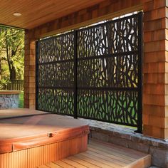 a hot tub sitting under a wooden roof next to a stone wall covered in leaves