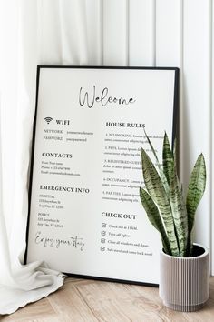 a welcome sign next to a potted plant on a wooden floor in front of a white wall