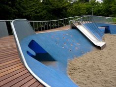 a skateboard ramp in the middle of a wooden decked area with trees in the background