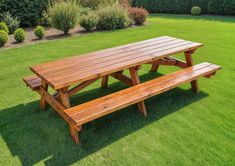 a wooden picnic table and benches in the grass